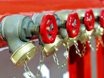 Four red valves located on fire protection equipment