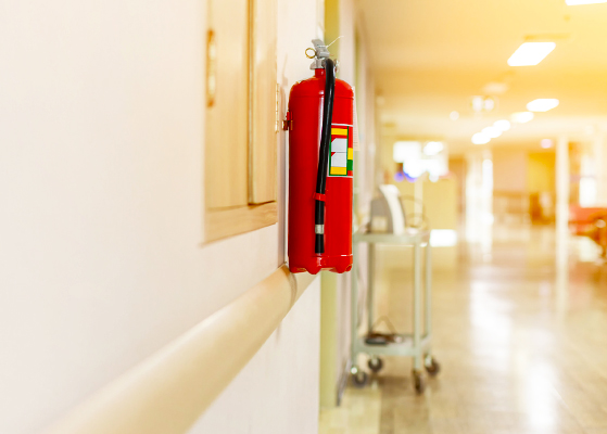 View of a fire extinguisher along a hospital hallway 