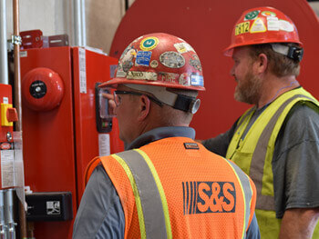 Two Shambaugh technicians inspection fire protection equipment at a facility