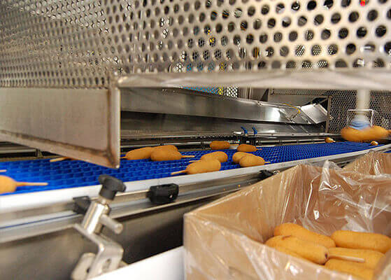 Corndogs moving along a frozen foods production line